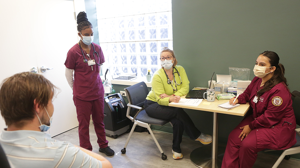 Nursing students talk with a client at BEDS Plus